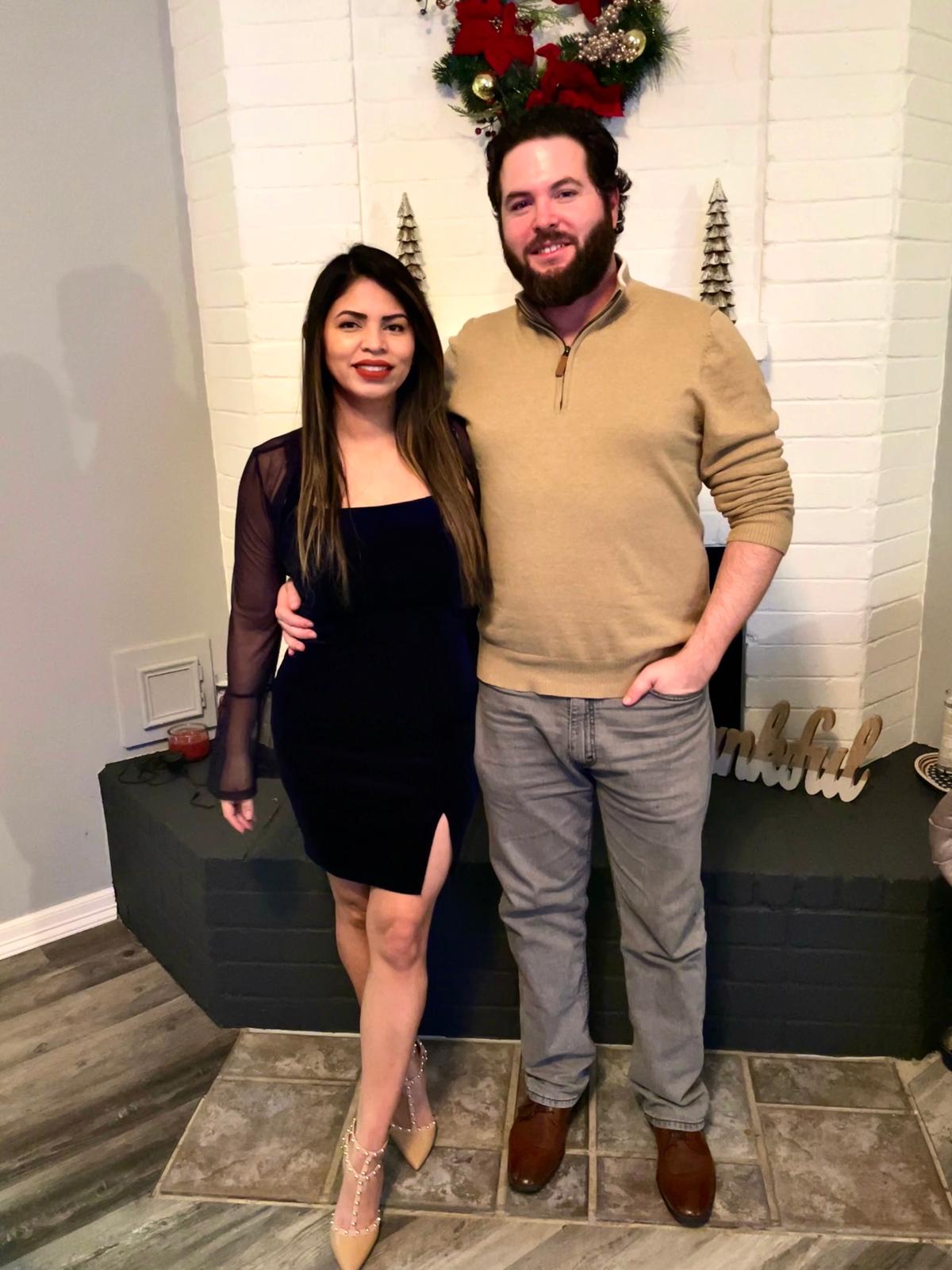 Karen and Travis dressed up together by the fireplace